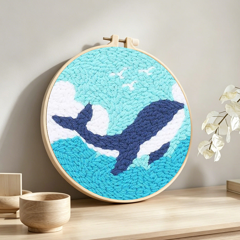 Whale and waves punch needle artwork displayed on a table