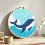 Whale and waves punch needle artwork displayed on a table