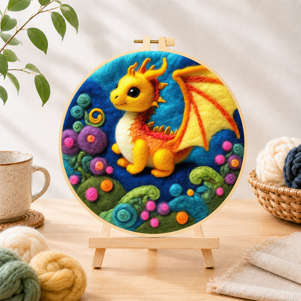 Finished whimsical baby dragon and colorful spiral plant needle felting displayed on a wooden easel