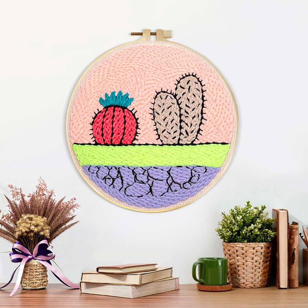 Finished whimsical cactus and cracked earth artwork displayed on a wall