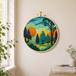 whimsical forest and rolling mountains needle felt wall art displayed in a bright home interior