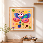 Finished whimsical rainbow dragonfly cross stitch artwork displayed as home decor