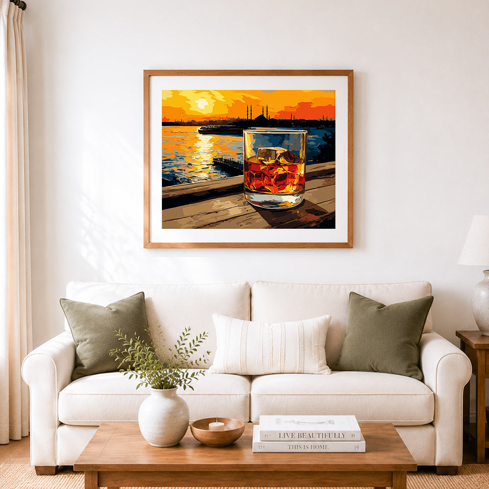 Finished whiskey glass on wooden pier at sunset cross stitch artwork displayed as home decor