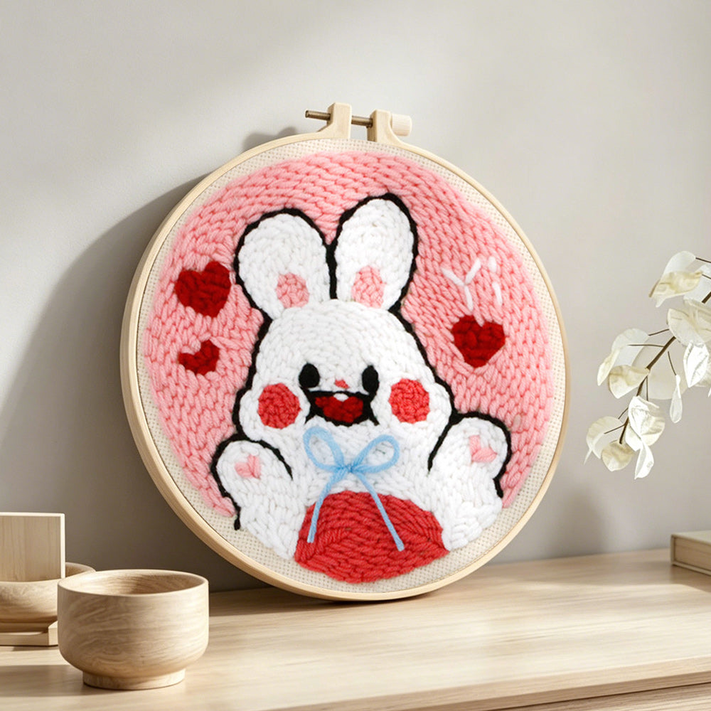 White bunny with hearts punch needle artwork displayed on a table