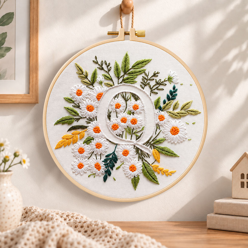 White daisy cluster and letter q embroidery hoop wall art displayed as warm and cozy handmade home decor