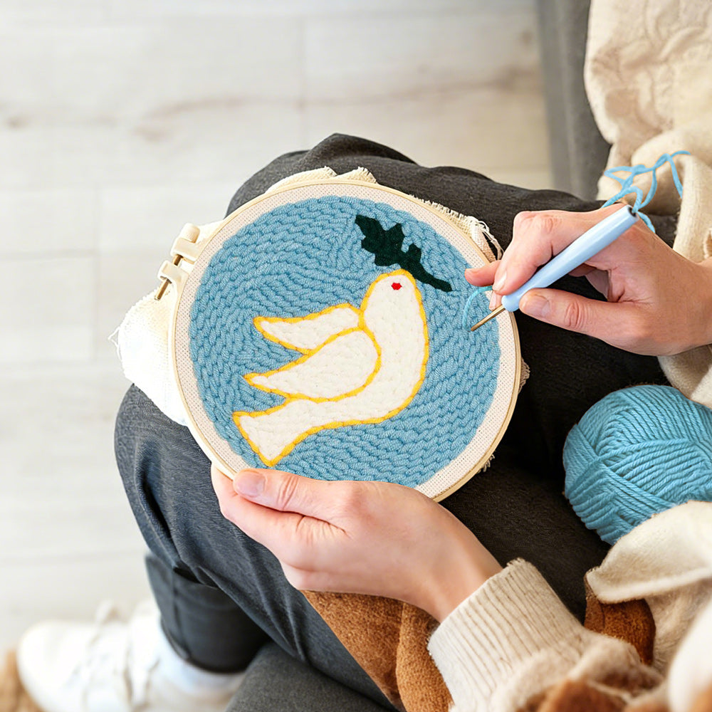 Creating handmade white dove and olive leaf punch needle artwork