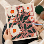 Creating handmade white florals on dusty pink background punch needle artwork