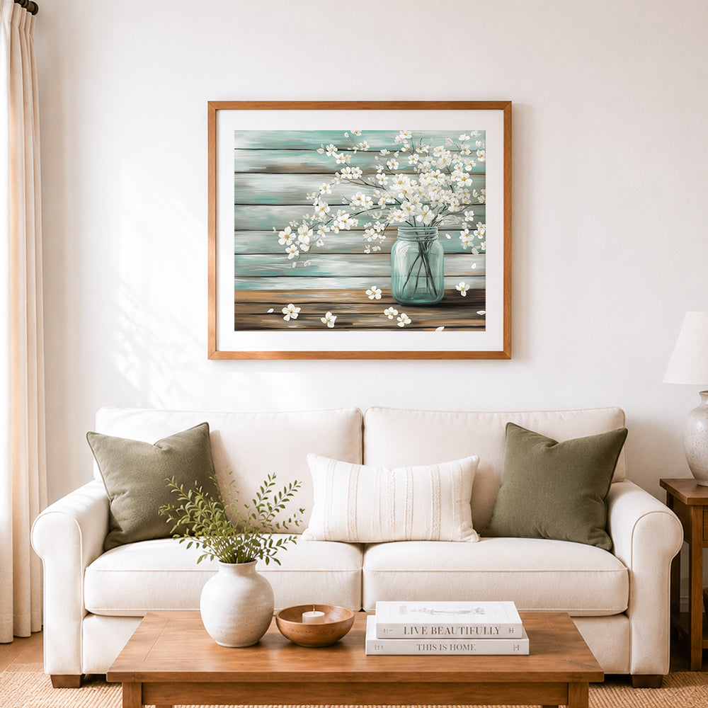 Finished white flowers in teal jar on rustic wood cross stitch artwork displayed as home decor