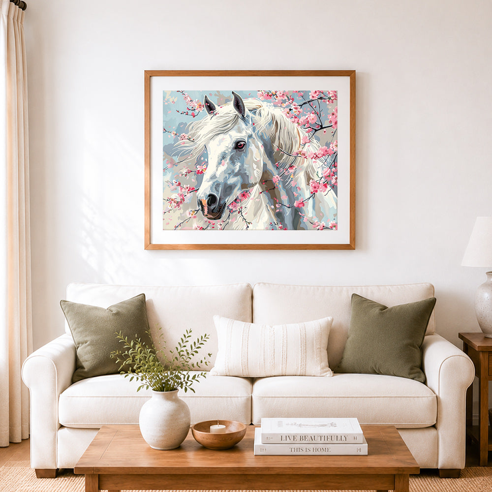 Finished white horse among cherry blooms cross stitch artwork displayed as home decor