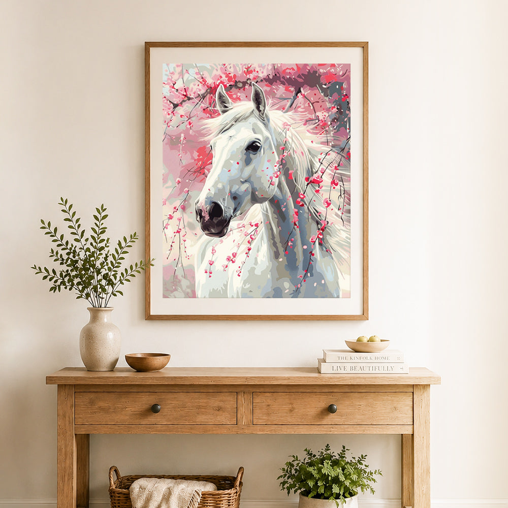 Finished white horse with cherry blossoms cross stitch artwork displayed as home decor