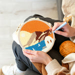 Creating handmade white house by blue sea under orange sky punch needle artwork