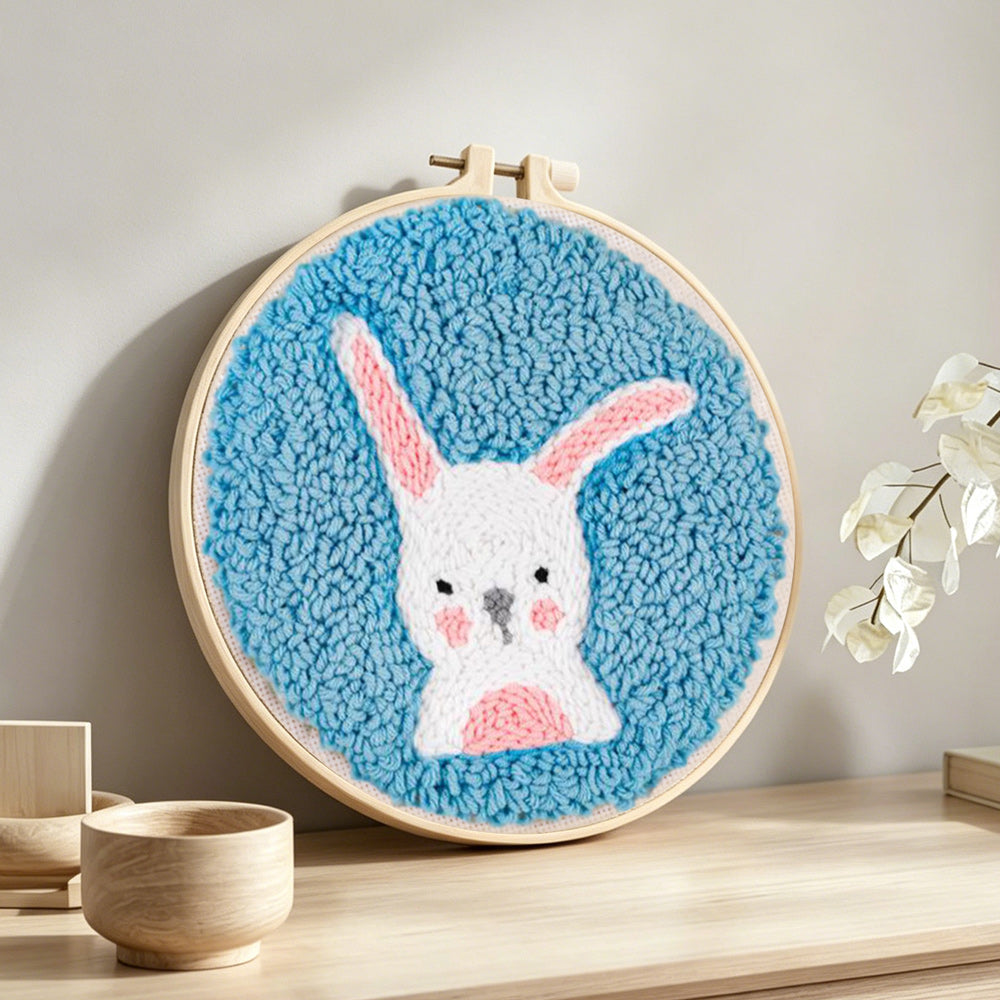 White rabbit with upright ears punch needle artwork displayed on a table