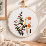 Wild berry and dandelion blooms embroidery hoop wall art displayed as warm and cozy handmade home decor