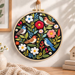 Wild birds and mixed flowers embroidery hoop wall art displayed as warm and cozy handmade home decor