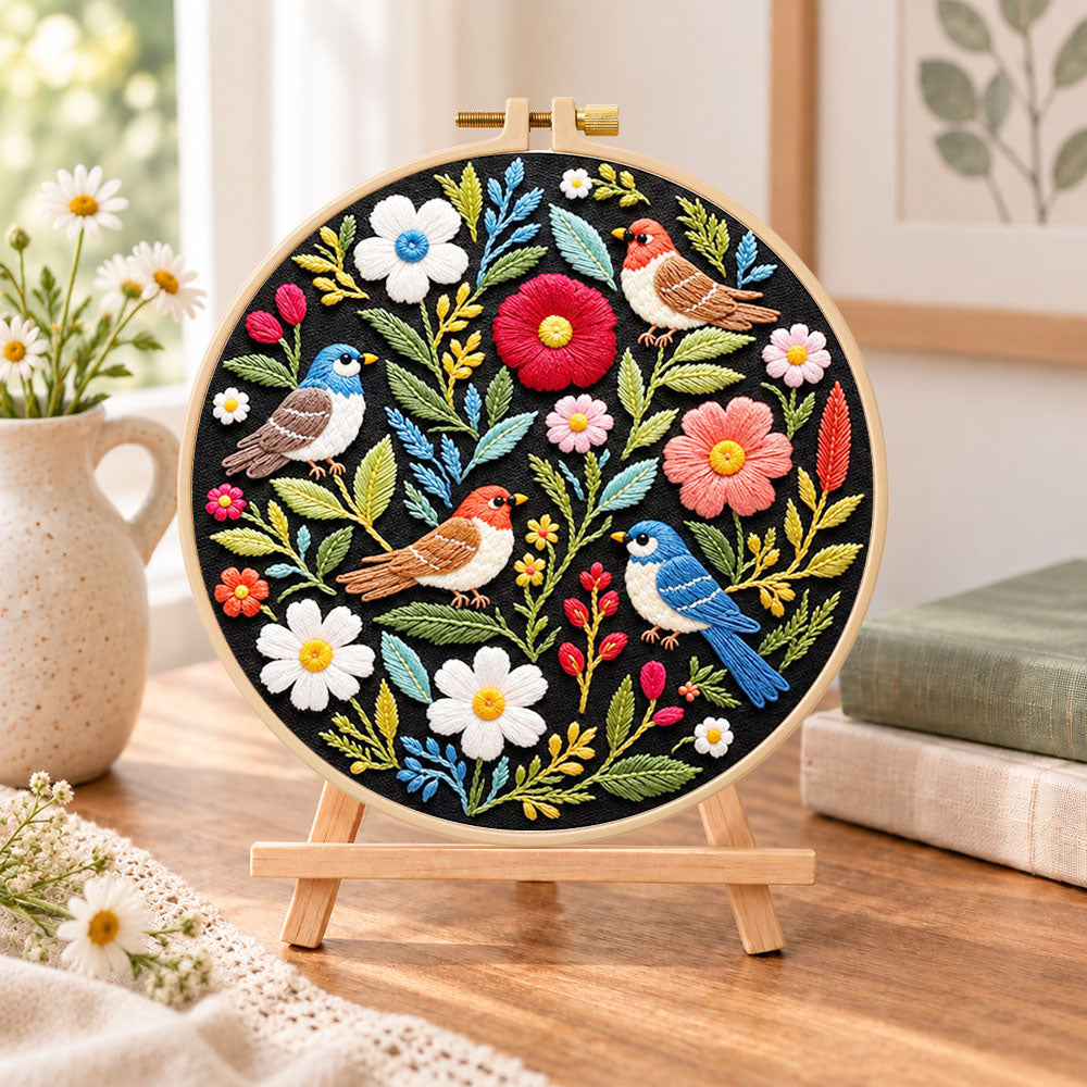 Wild birds and mixed flowers embroidery kit finished hoop displayed on a wooden stand as cozy tabletop decor