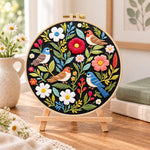Wild birds and mixed flowers embroidery kit finished hoop displayed on a wooden stand as cozy tabletop decor
