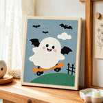 Winged ghost skateboarding punch needle artwork displayed on a table