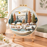 Winter camping valley embroidery kit finished hoop displayed on a wooden stand as cozy tabletop decor