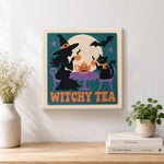 Finished witch and cat having tea artwork displayed on a wall