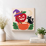 Finished witch apple cauldron artwork displayed on a wall