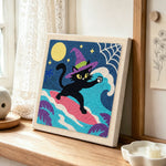 Witch black cat surfing under full moon punch needle artwork displayed on a table