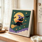Witch cat on broom punch needle artwork displayed on a table