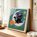 Witch cat on broomstick punch needle artwork displayed on a table