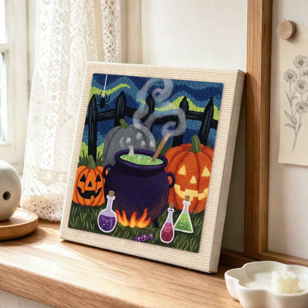 Witch cauldron and pumpkins punch needle artwork displayed on a table