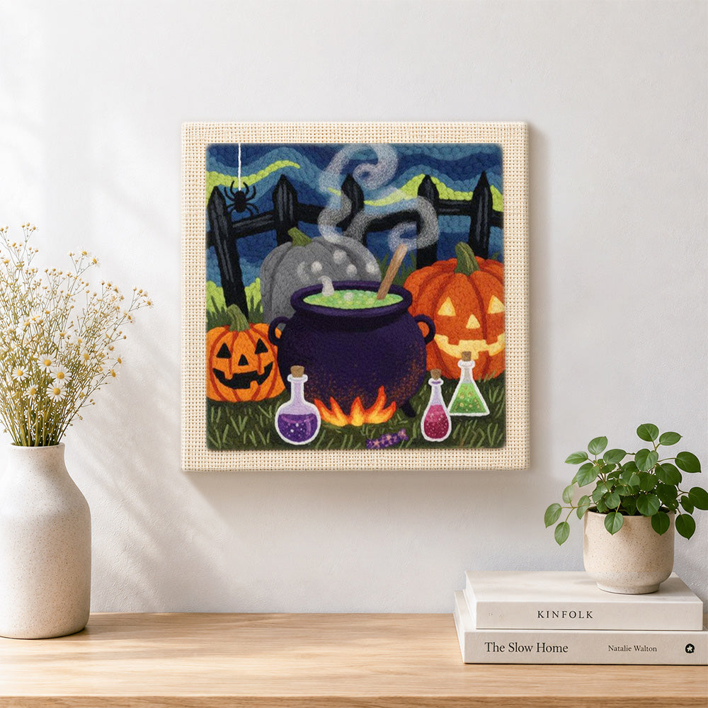 Finished witch cauldron and pumpkins artwork displayed on a wall