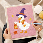 Creating handmade witch duck holding lantern punch needle artwork