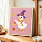 Witch duck holding lantern punch needle artwork displayed on a table