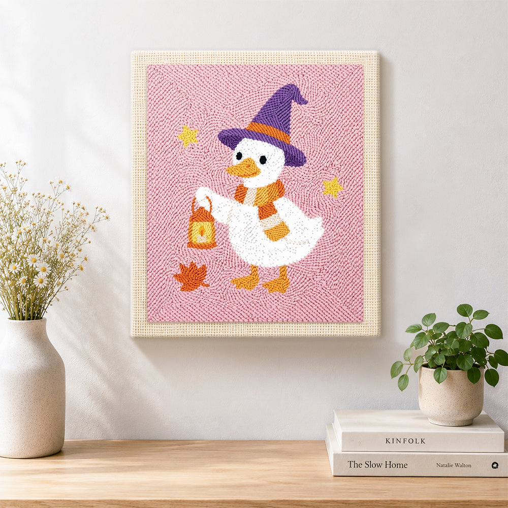 Finished witch duck holding lantern artwork displayed on a wall