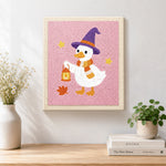Finished witch duck holding lantern artwork displayed on a wall