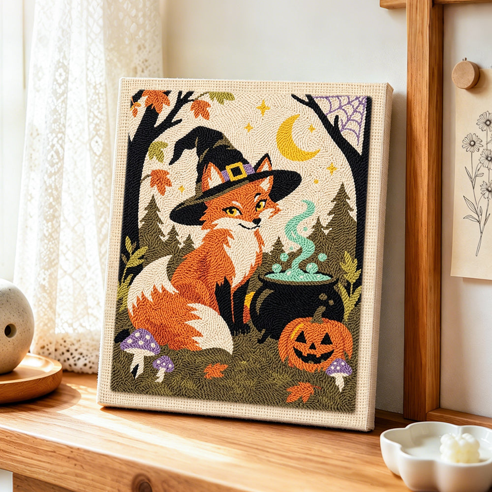 Witch fox with magic cauldron punch needle artwork displayed on a table