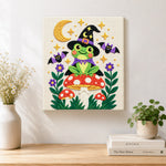 Finished witch frog on mushroom artwork displayed on a wall