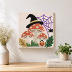 Finished witch hat mushrooms with spider web artwork displayed on a wall