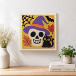Finished witch hat skull and black cat artwork displayed on a wall