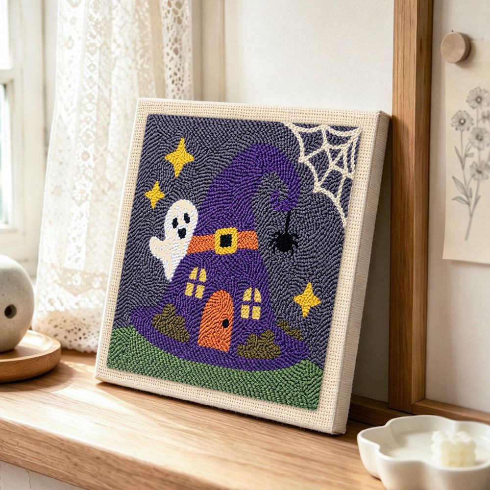 Witch hat tiny house punch needle artwork displayed on a table