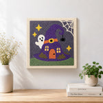 Finished witch hat tiny house artwork displayed on a wall