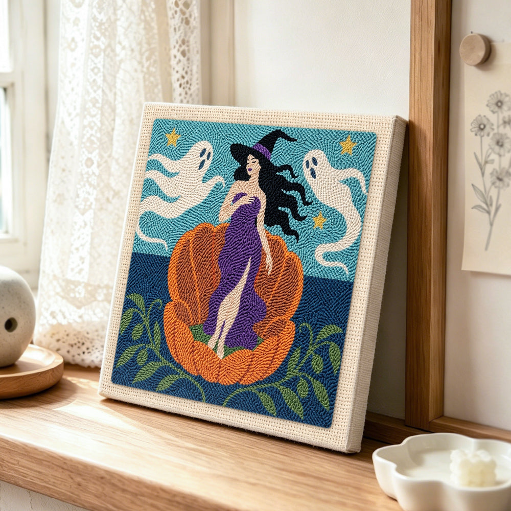 Witch in giant pumpkin punch needle artwork displayed on a table