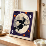 Witch moon silhouette punch needle artwork displayed on a table