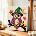 Witch owl on branch punch needle artwork displayed on a table