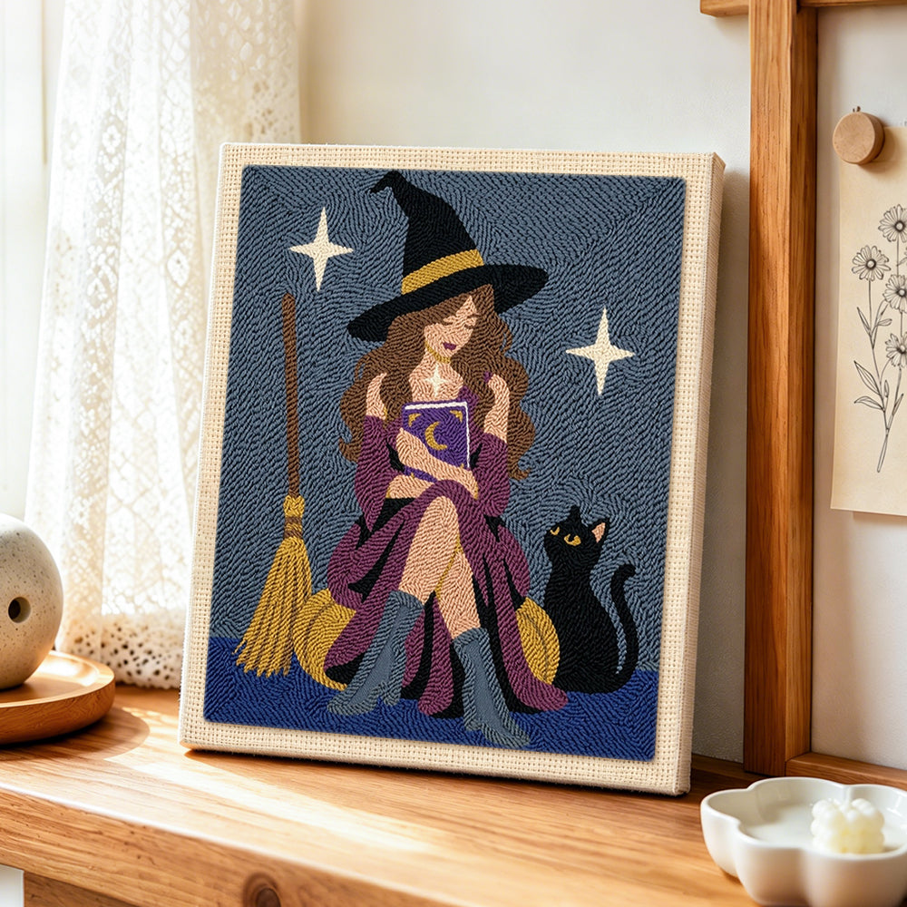Witch reading magic book with cat punch needle artwork displayed on a table