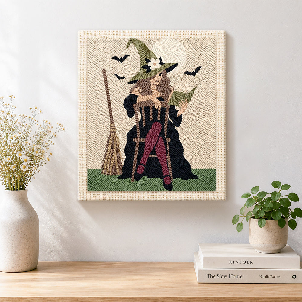 Finished witch seated with spell book artwork displayed on a wall