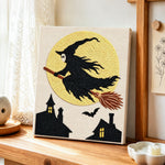 Witch silhouette against full moon punch needle artwork displayed on a table