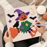 Creating handmade witch soaring with pumpkin punch needle artwork