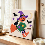 Witch soaring with pumpkin punch needle artwork displayed on a table