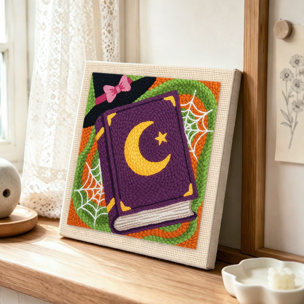 Witch spell book punch needle artwork displayed on a table