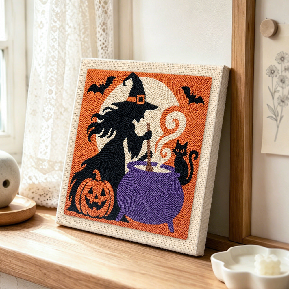 Witch stirring magic cauldron punch needle artwork displayed on a table