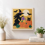 Finished witch watering pumpkins artwork displayed on a wall